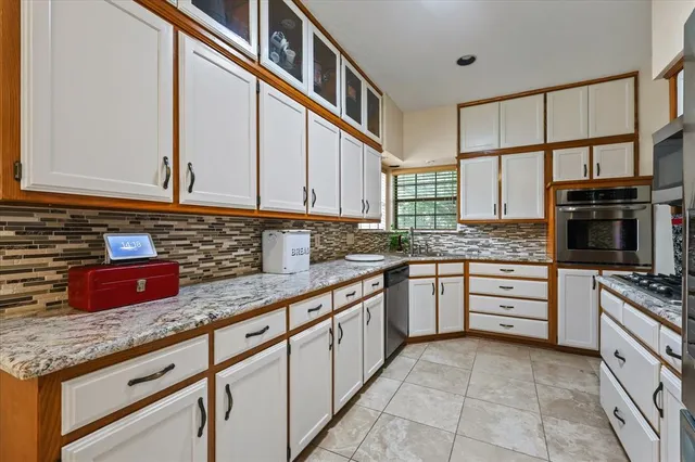 a kitchen with stainless steel appliances granite countertop a sink and a stove