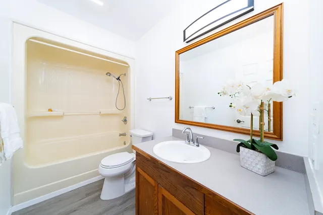 a bathroom with a granite countertop sink toilet and shower