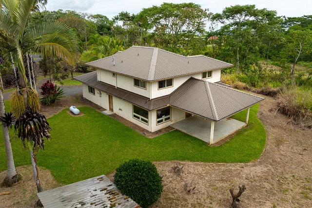 an aerial view of a house with backyard