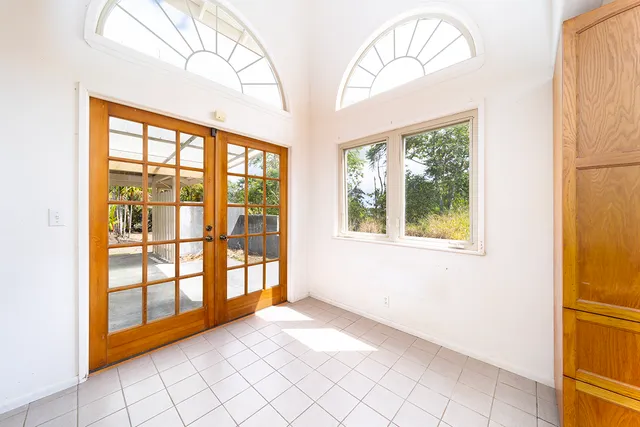 a view of an empty room with a window and a ceiling fan