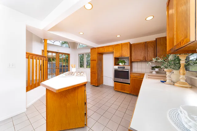 a large kitchen with a large window and stainless steel appliances