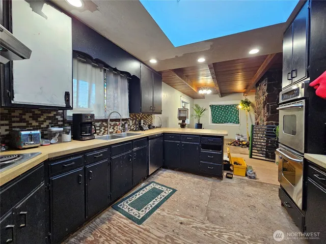 a kitchen with lots of counter top space and stainless steel appliances