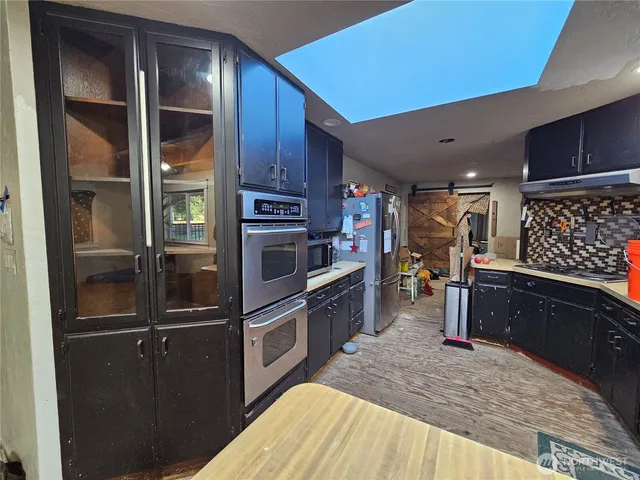 a kitchen with granite countertop stainless steel appliances and wooden cabinets