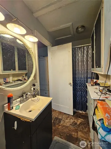 a bathroom with a sink vanity granite and a mirror