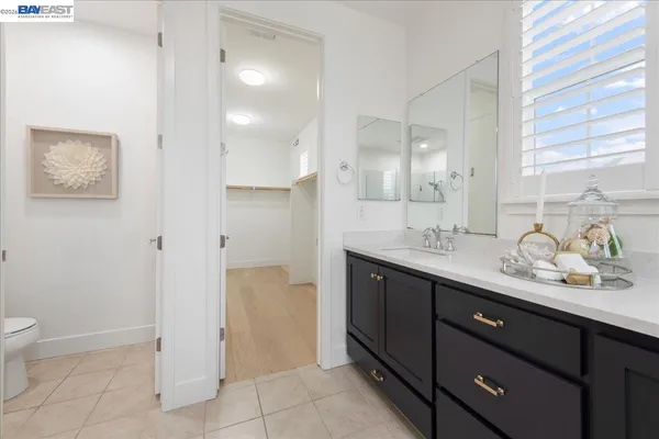 a bathroom with a granite countertop sink a toilet a and mirror