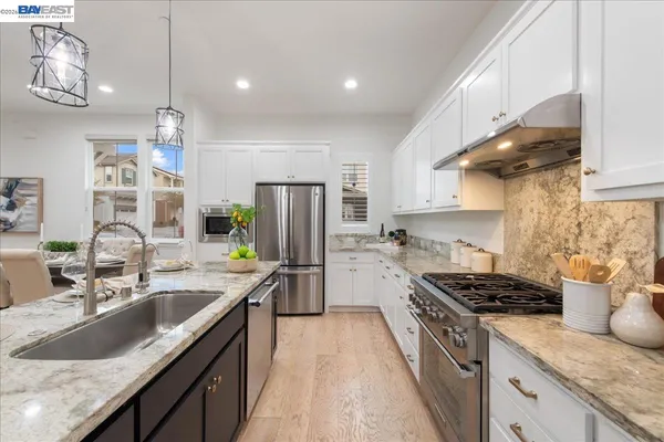 a kitchen with stainless steel appliances granite countertop a sink stove and refrigerator
