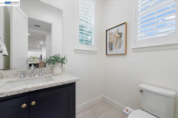 a bathroom with a granite countertop sink a toilet and a window