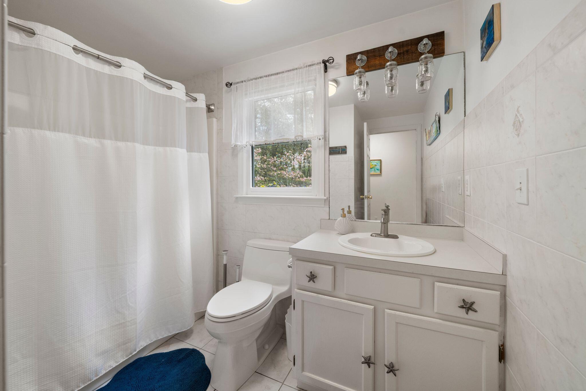 40 Sam Ryder Road Chatham, MA 02633 - Photo 15 of 42 a bathroom with a sink a toilet a mirror a vanity and shower