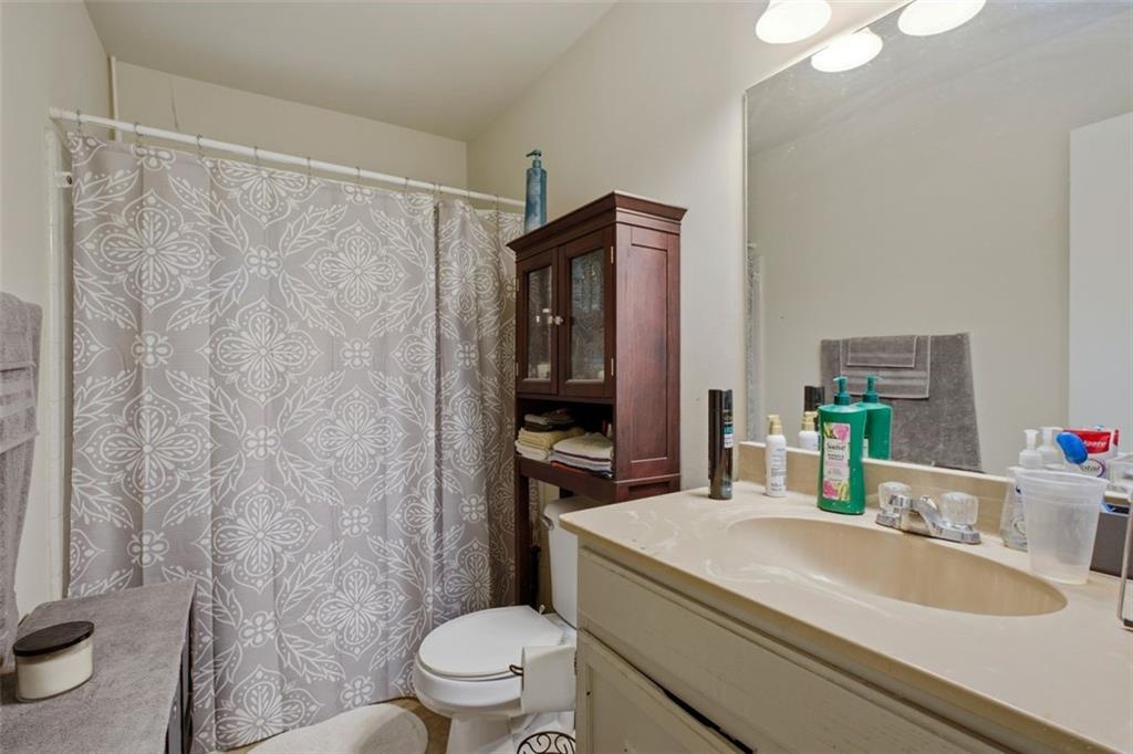 913 Old Noonday Sch House Road Marietta, GA 30066 - Photo 13 of 42 a bathroom with a granite countertop sink toilet a mirror and shower curtain