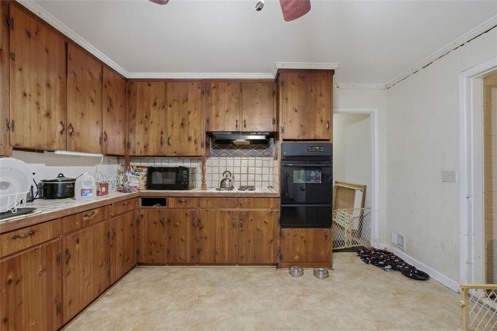 913 Old Noonday Sch House Road Marietta, GA 30066 - Photo 10 of 42 a kitchen with kitchen island granite countertop a stove top oven a sink a counter space and cabinets