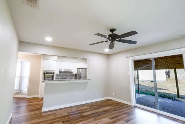 a view of wooden floor and a chandelier fan in a room