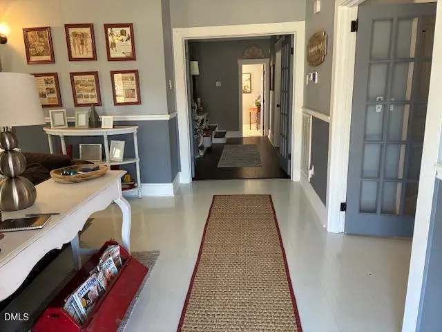 a view of a hallway with couches and dining area with chandelier