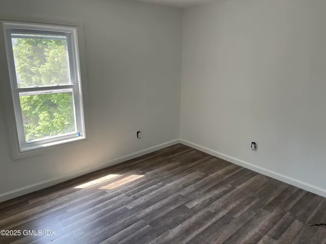 a view of a room with wooden floor and window