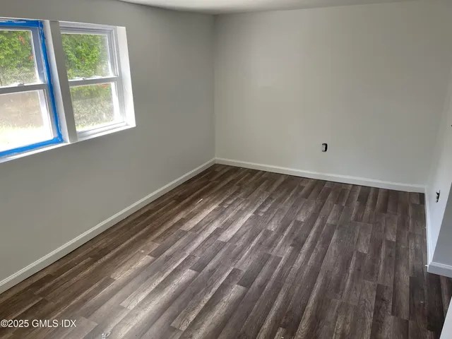 a view of a room with wooden floor and windows