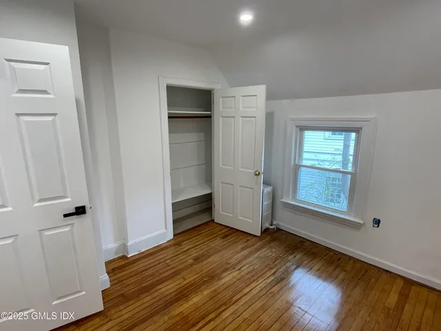 a view of a room with wooden floor and window