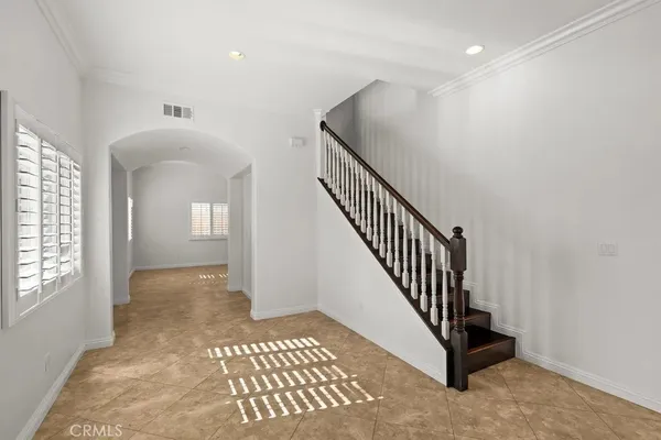 a view of a hallway with entryway and stairs