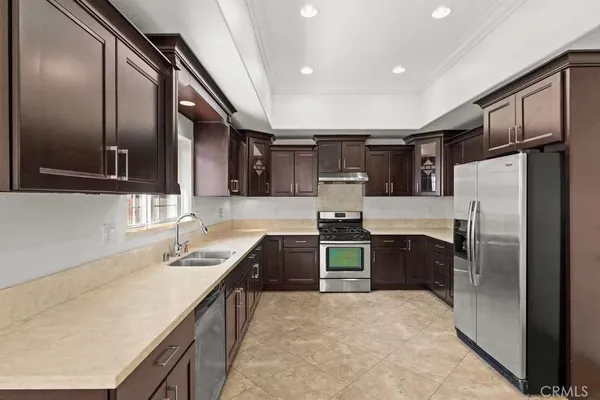 a kitchen with stainless steel appliances granite countertop a sink refrigerator and cabinets