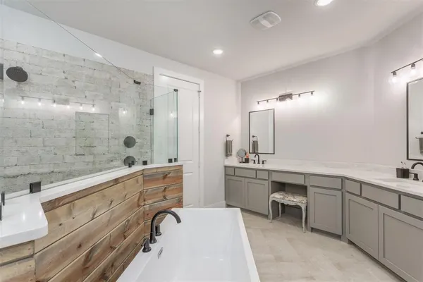 a bathroom with a double vanity sink a toilet a mirror and shower