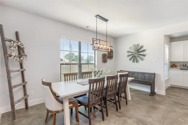 a dining room with furniture a chandelier and window