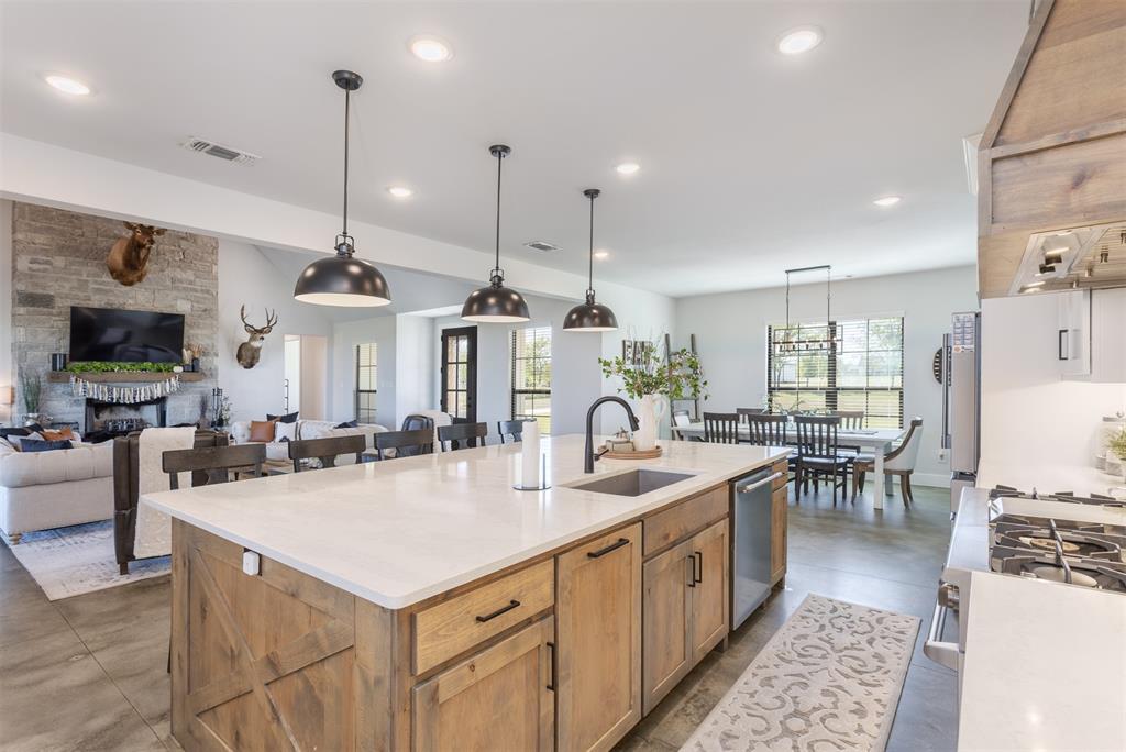 1810 Jc Maples Road Gunter, TX 75058 - Photo 27 of 27 a large kitchen with kitchen island a sink a counter space and living room view