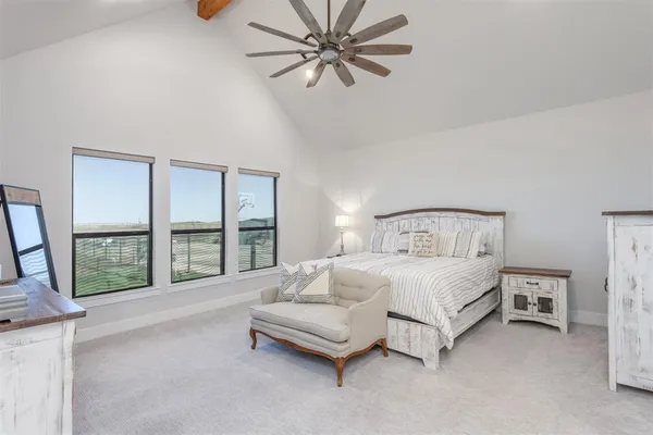 a spacious bedroom with a bed a couch and a large window