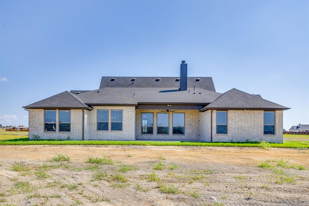 10611 Rye Bread Lane Venus, TX 76084 - Photo 35 of 36 Brick exterior with a dark-pitched roof, multiple windows, a prominent chimney, and a small area of green lawn