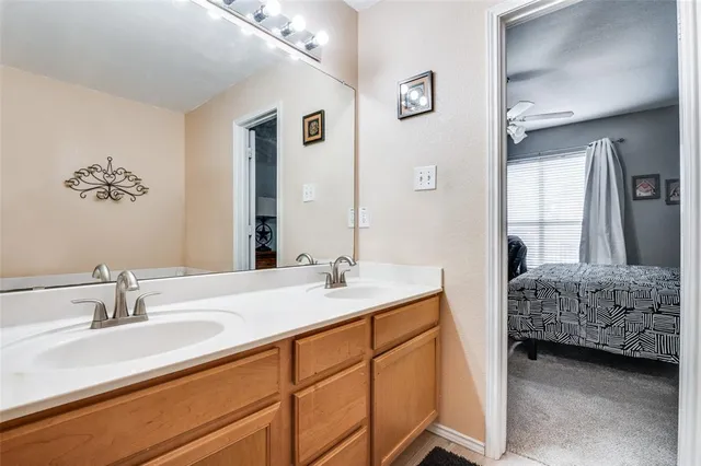 a en suite bathroom with a double vanity sink and a mirror