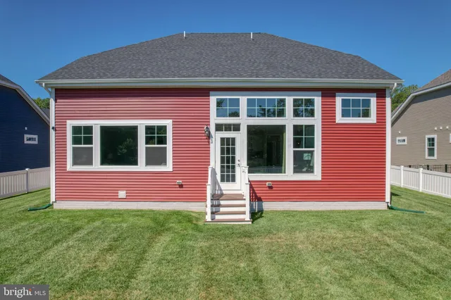 a kitchen with stainless steel appliances granite countertop a refrigerator a sink a stove and white cabinets