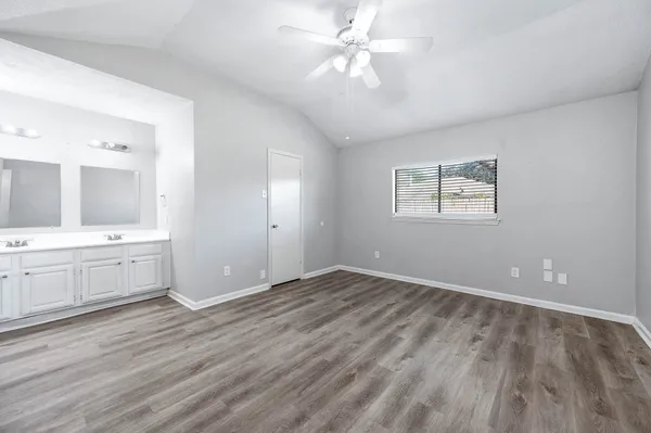 a view of an empty room and window and wooden floor