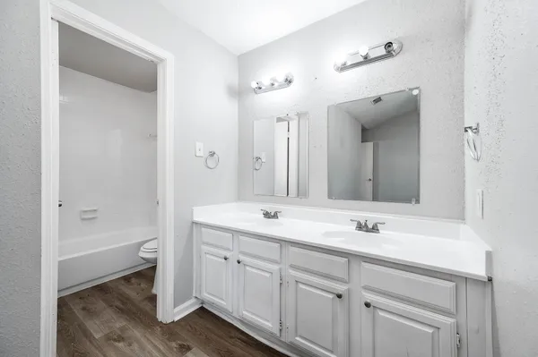 a bathroom with a sink double vanity granite tub and a mirror