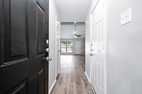 a view of a hallway with wooden floor