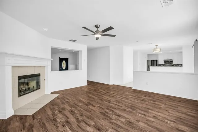 a view of an empty room with window and wooden floor