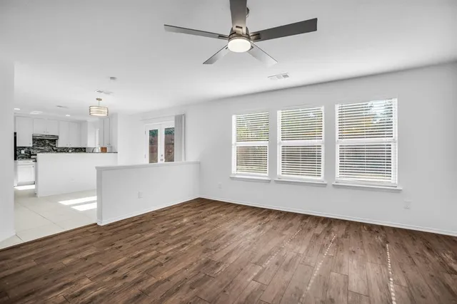 a view of kitchen with stainless steel appliances granite countertop a refrigerator a sink a microwave and cabinets