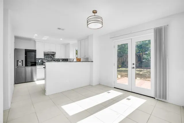 a kitchen with granite countertop a sink stainless steel appliances and white cabinets