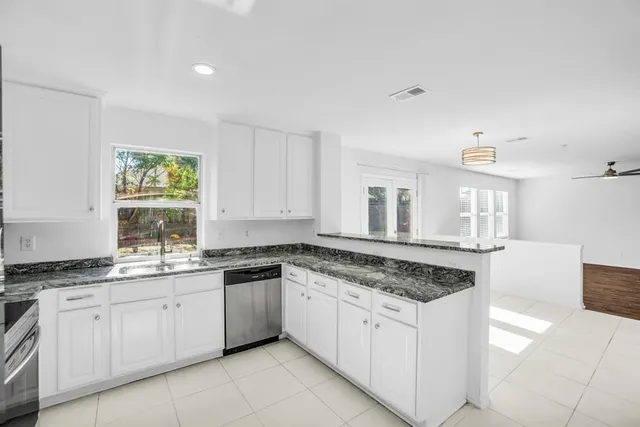 a kitchen with granite countertop white cabinets and appliances