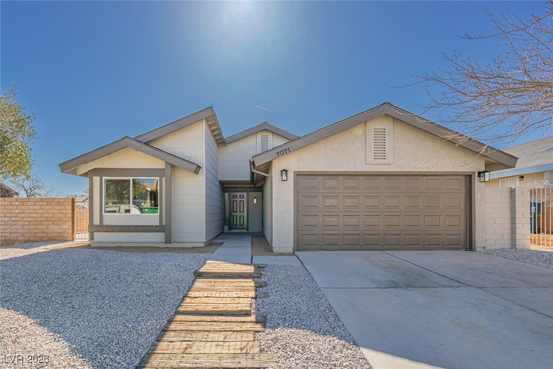 View of front of home with concrete driveway, an attached garage, and stucco siding