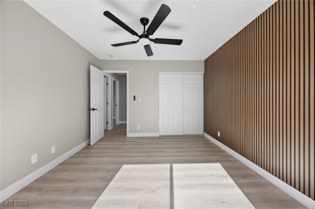 7071 Wedgewood Way Las Vegas, NV 89147 - Photo 21 of 37 Unfurnished bedroom with light wood-style flooring, a closet, ceiling fan, and an accent wall