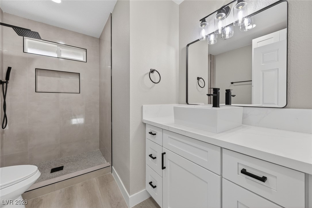 7071 Wedgewood Way Las Vegas, NV 89147 - Photo 22 of 37 Full bathroom with vanity, tiled shower, and light wood finished floors