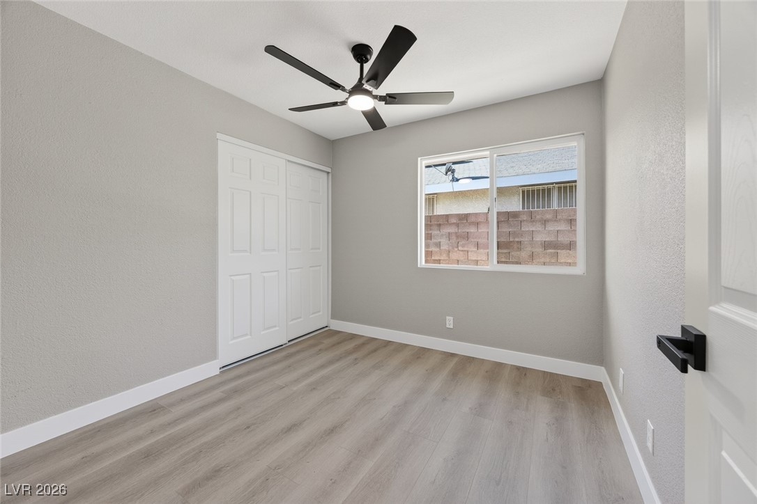 7071 Wedgewood Way Las Vegas, NV 89147 - Photo 27 of 37 Unfurnished bedroom featuring a ceiling fan, light wood-style flooring, and a closet