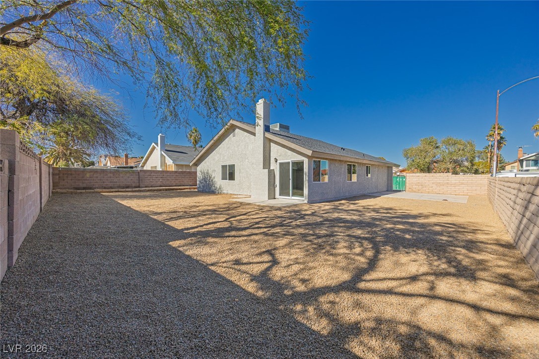 7071 Wedgewood Way Las Vegas, NV 89147 - Photo 30 of 37 Rear view of property featuring a chimney, a fenced backyard, a patio area, and stucco siding