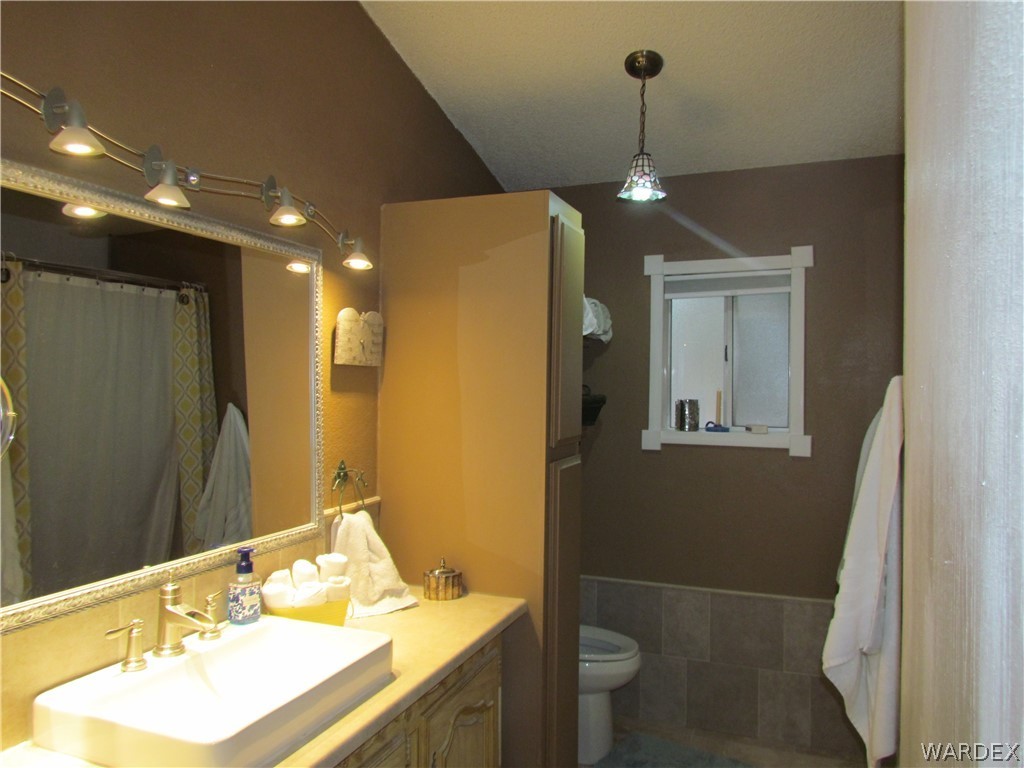 3500 Aztec Road Golden Valley, AZ 86413 - Photo 14 of 23 a bathroom with a sink a toilet a mirror and vanity