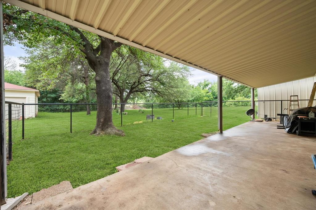 126 Smallwood Court Springtown, TX 76082 - Photo 6 of 24 Over 40 foot of Covered Back Patio with view of the shop and garage area.