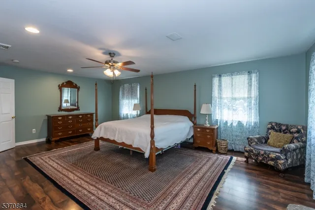 a spacious bedroom with a bed window and couch