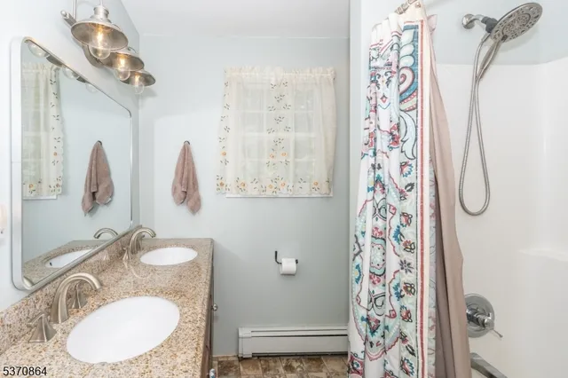 a bathroom with a sink mirror and shower