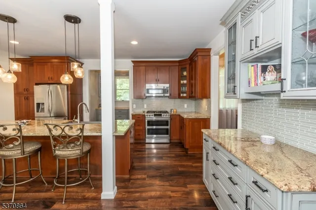 a large kitchen with stainless steel appliances kitchen island granite countertop a large stove a sink dishwasher and cabinets with wooden floor