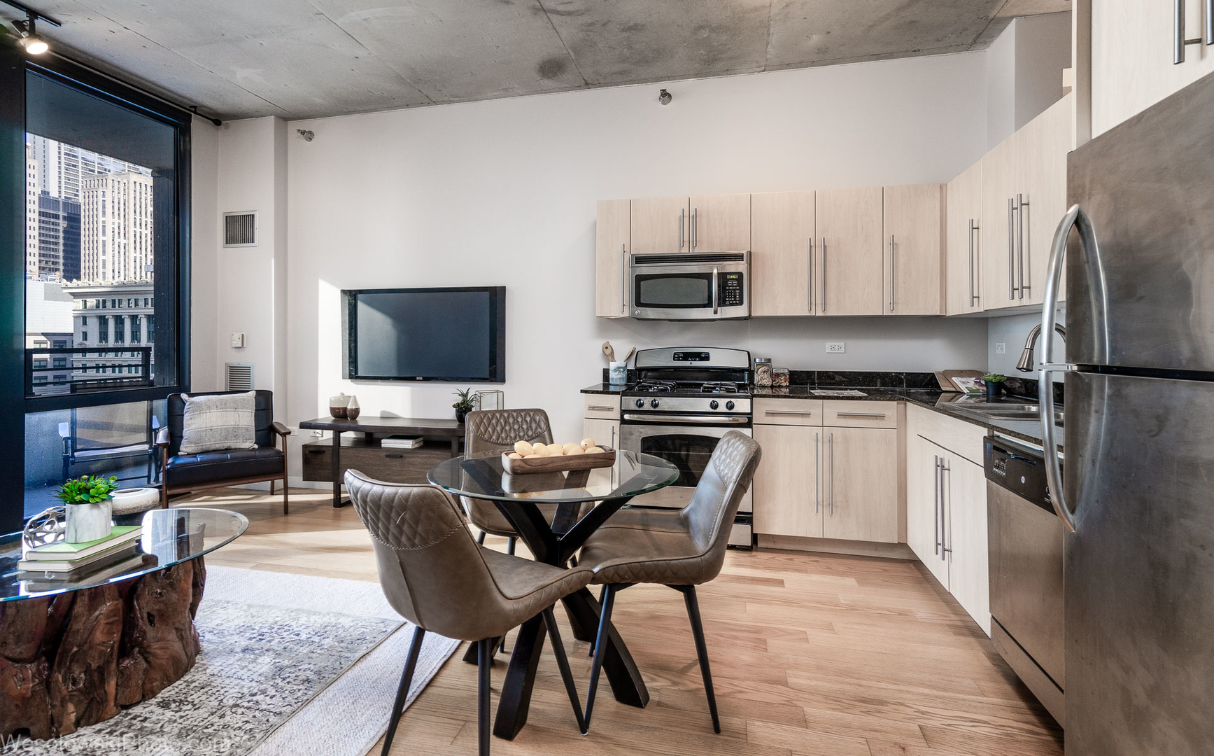 235 West Van Buren Street, Unit 2417 Chicago, IL 60607 - Photo 6 of 22 a kitchen with stainless steel appliances a stove a sink a microwave a refrigerator a stove top oven a dining table and chairs