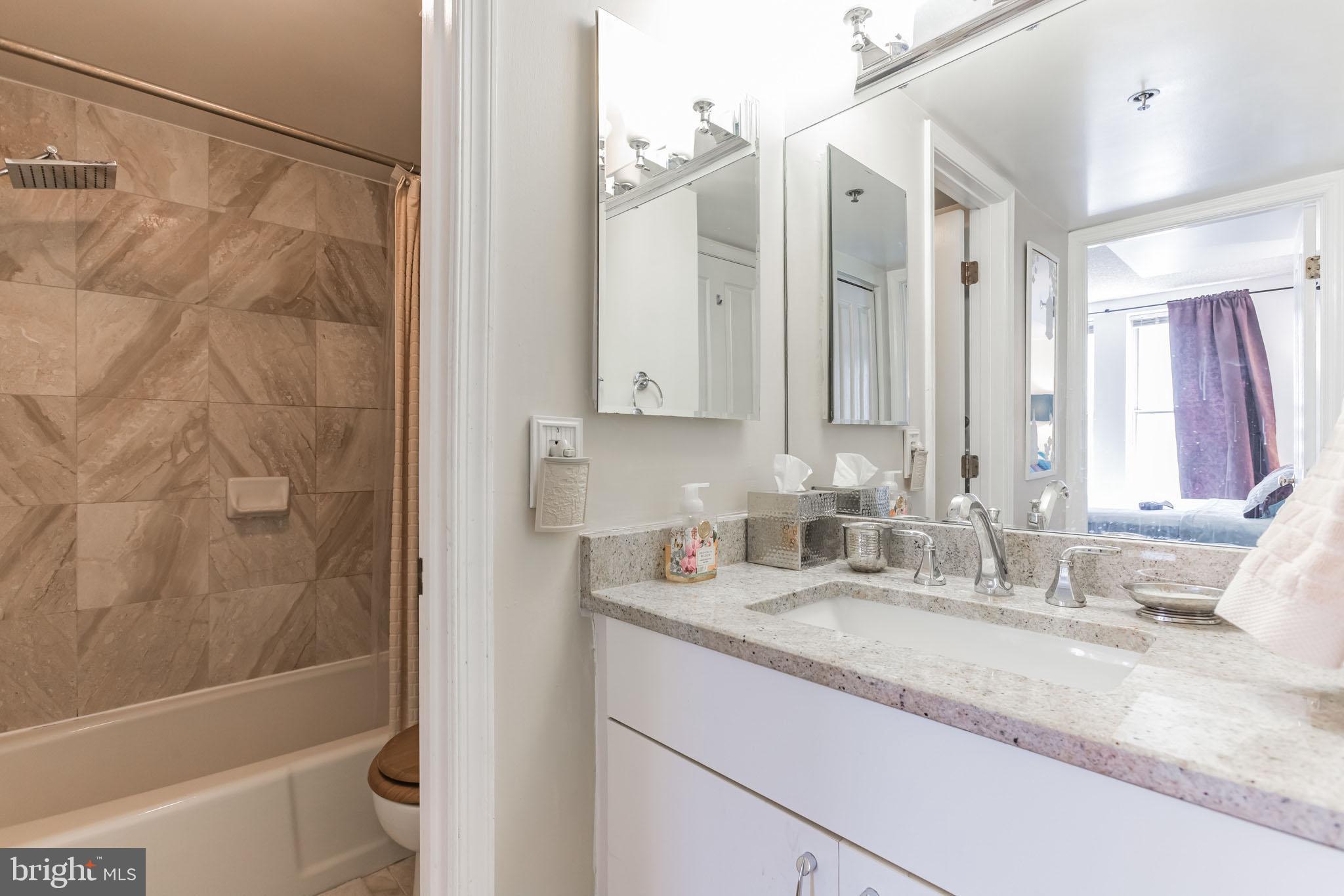 601 Pennsylvania Avenue Northwest, Unit 705 Washington, DC 20004 - Photo 21 of 29 a bathroom with a granite countertop sink toilet and shower