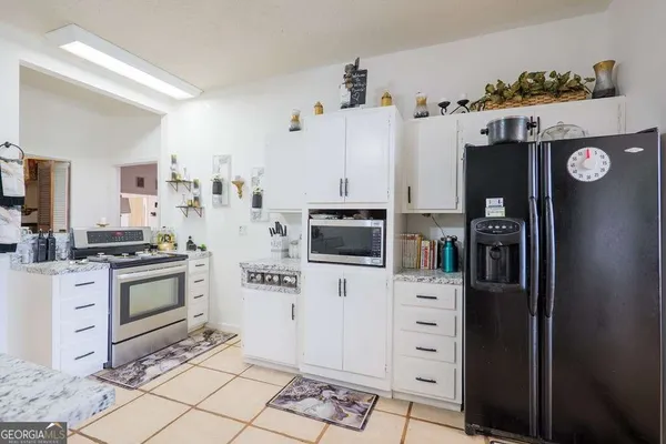 a kitchen with stainless steel appliances a stove a refrigerator and cabinets
