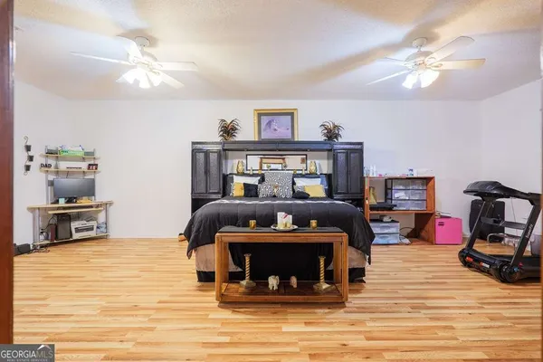 a bedroom with bed and wooden floor