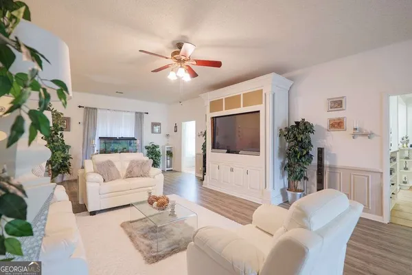 a living room with furniture a flat screen tv and a potted plant